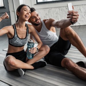happy-sporty-young-couple-taking-selfie-with-smart-PY9GLQZ